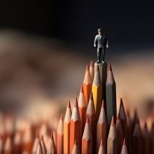 Businessman standing on top of pencils. Leadership, uniqueness,