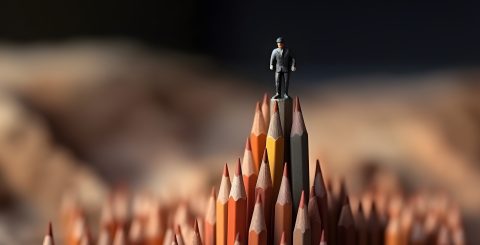 Businessman standing on top of pencils. Leadership, uniqueness,