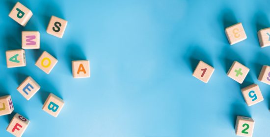 Colorful wooden cubes with letter, numbers scattered on blue background. learning, increasing IQ, development for children. Top view of children's toys. Educational games.